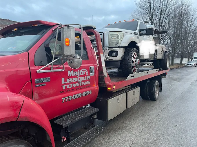 Heavy-duty pickup truck loaded on a Major League flatbed at dawn